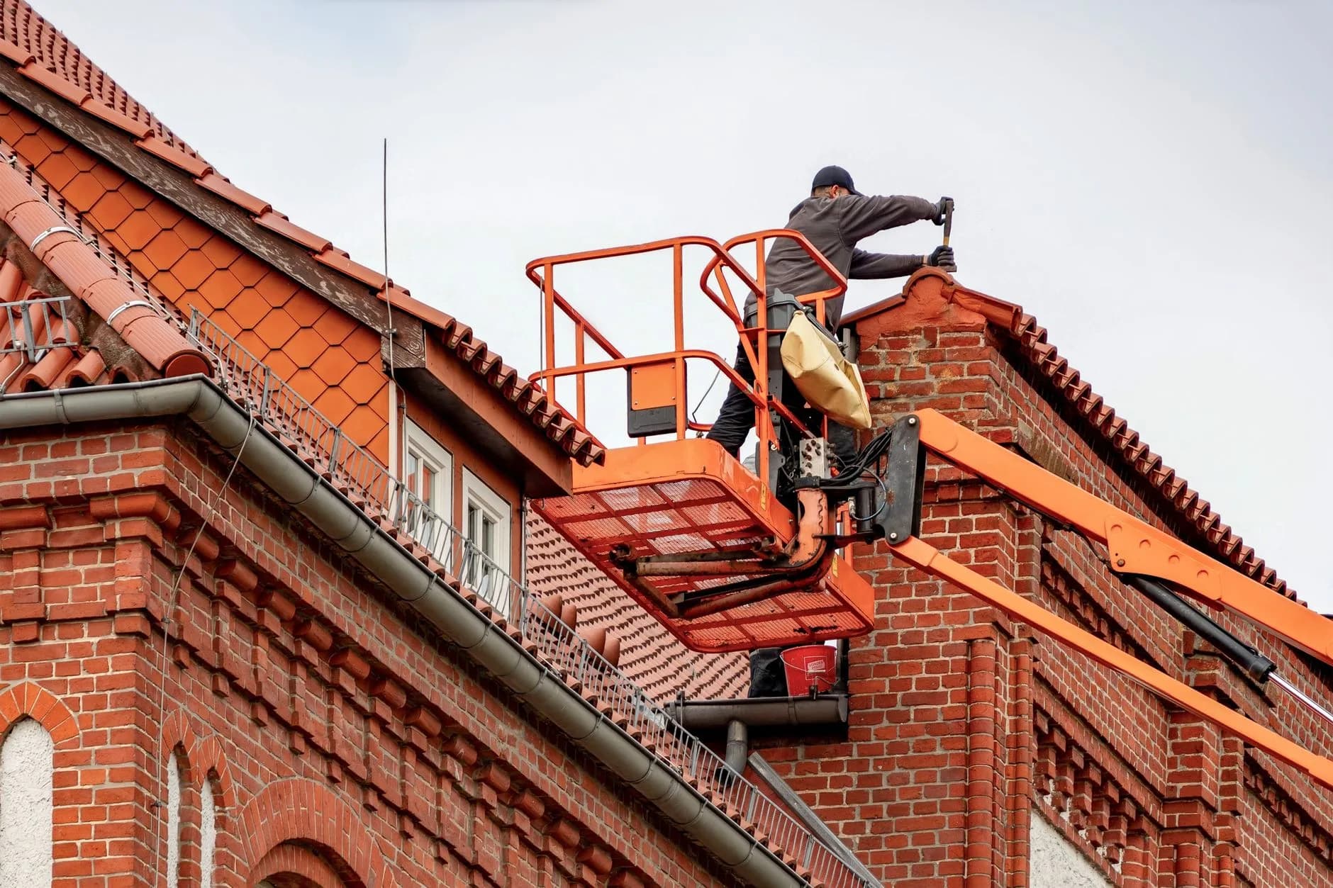 Cleaning a house gutter from a ladder